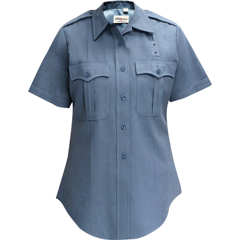 Product shot of a Flying Cross women's short-sleeve, button-down shirt featuring a slate blue hue, two breast pockets, and a curved hemline