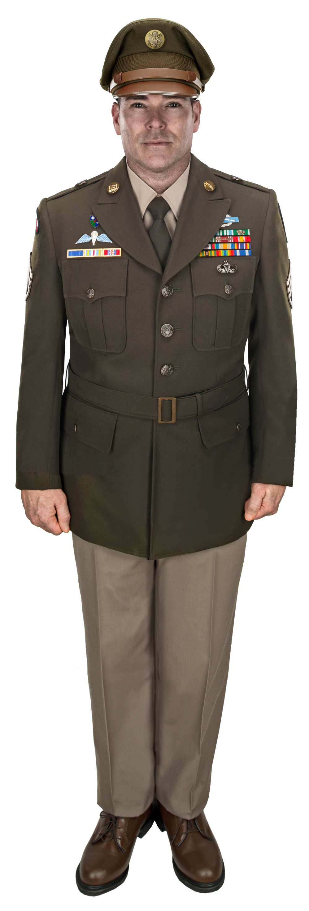 Photo of a male US Army officer in a green service uniform with tan trousers and brown shoes showcasing colorful ribbons, badges, and a US Army insignia on his hat.