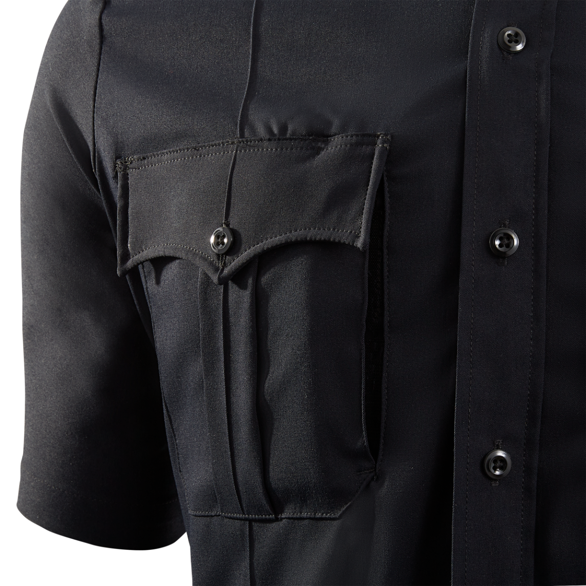 Close-up product shot of a dark navy blue uniform shirt showing a breast pocket with a unique V-shaped flap, three dark buttons, and crisp pleats showcasing the fabric texture