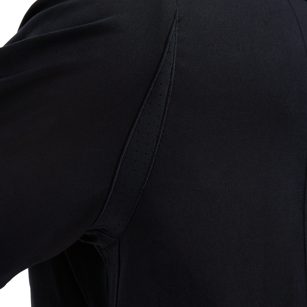 Close-up of dark fabric showcasing a unique seam detail with perforated accents and subtle texture variations