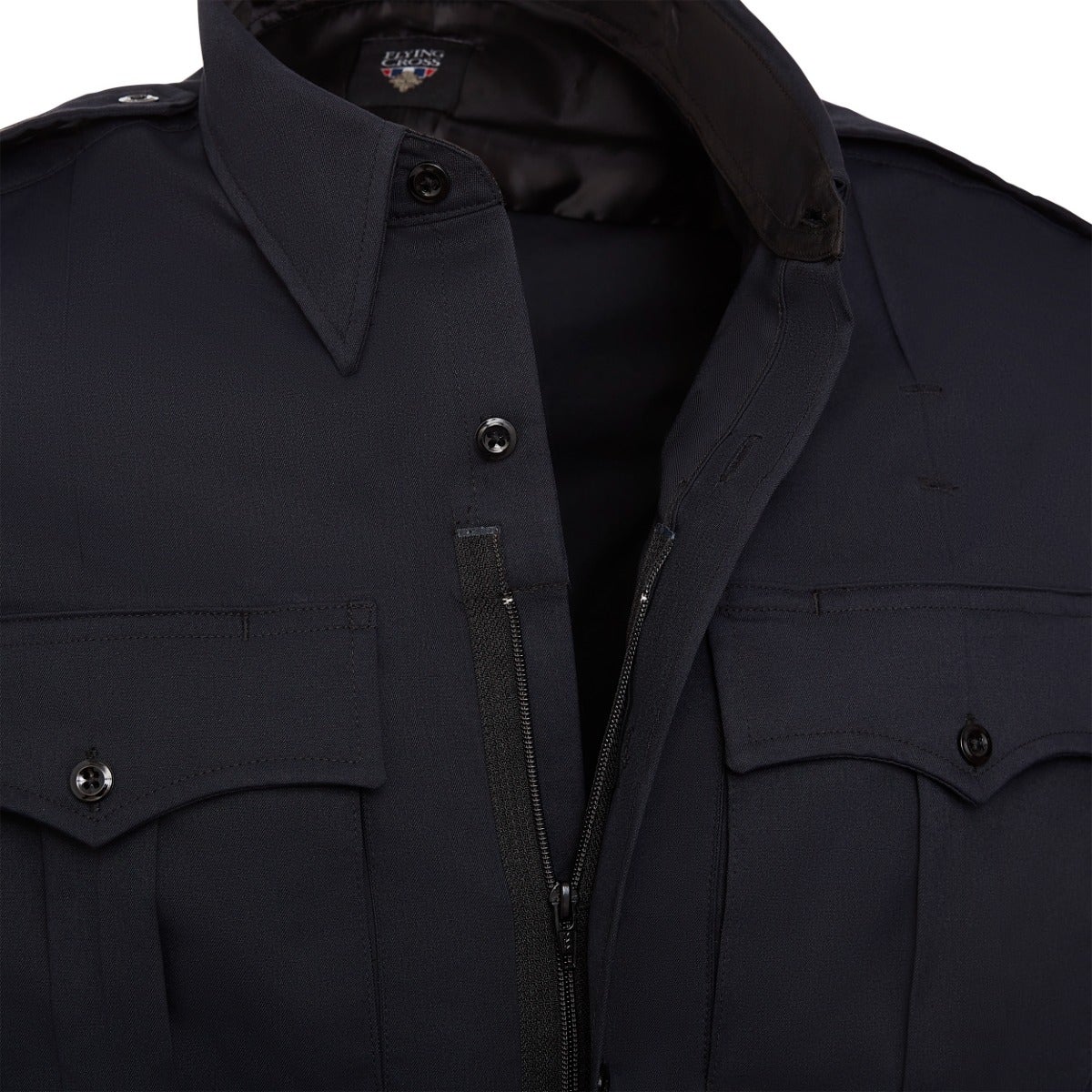 Close-up of a Flying Cross navy blue long-sleeve shirt featuring a concealed zipper, button closures, and distinct flap pockets showcasing the brand's logo on the collar