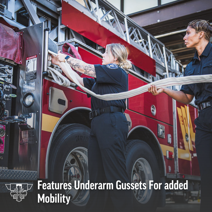 Photograph of two firefighters preparing a firehose in front of a red firetruck with visible large tires and a ladder a woman with tattoos and a smartwatch and another woman with short hair are shown deploying the hose