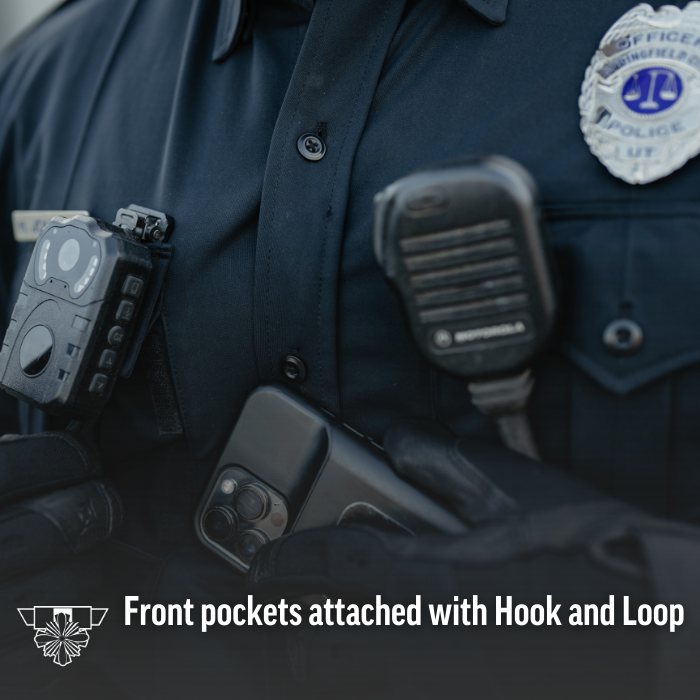 Photograph of a police officer's uniform showing a body camera, Motorola radio, smartphone in a case, and a police badge with a scales of justice emblem, all fastened with hook and loop to the dark fabric with visible buttons