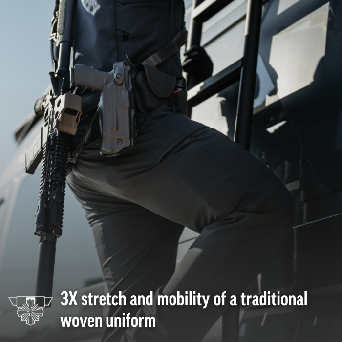 Photograph of a law enforcement officer climbing a vehicle's ladder, carrying a rifle and pistol with a tan optic and black holster, wearing tactical pants near a dark vehicle in an outdoor setting