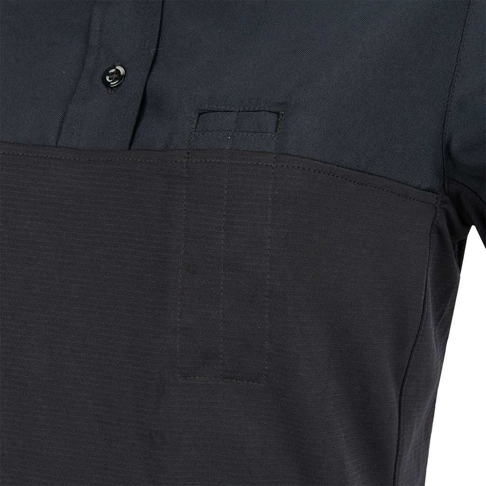 Close-up of a dark navy blue polo shirt featuring a contrasting textured lower section a small pocket and subtle stitching details