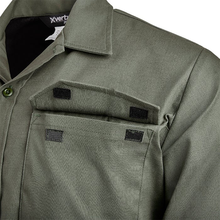 Close-up of a Vertx shirt showing olive green fabric, black hook-and-loop closures on the chest pockets, and a buttoned collar