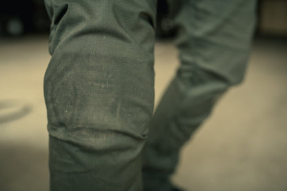 Close-up photograph of a person's khaki pants showing texture and subtle creases in the fabric.