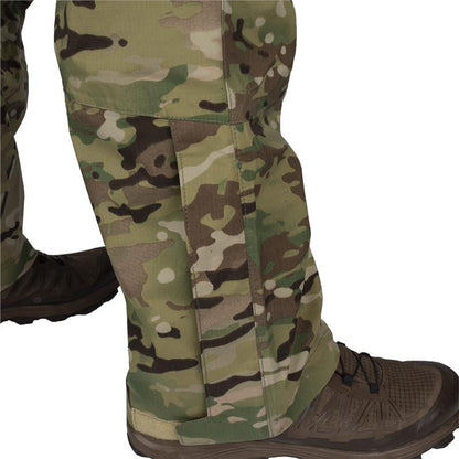 Product shot showing OCP camouflage pants with integrated boot gaiters featuring tan stitching and a multi-toned pattern of greens and browns over dark brown hiking boots
