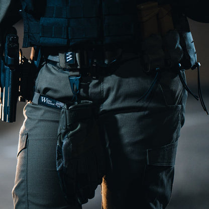 Photography Wilder Tactical person wearing tactical pants and gear including a handgun and gloves at night
