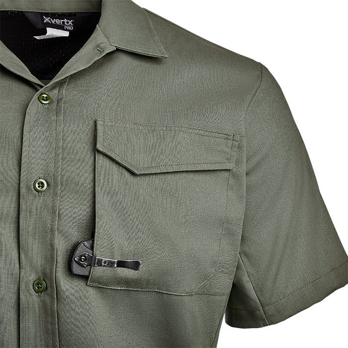 Product shot showing a close-up of a Vertx Pro olive green short-sleeved shirt with multiple pockets and a black tool clipped into a chest pocket featuring button closures and a subtle textured fabric