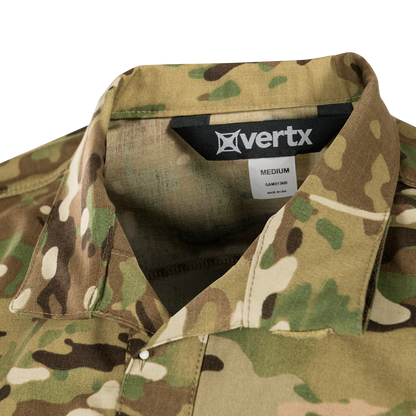 Product shot of a Vertx medium shirt in MultiCam camouflage featuring a black label tan stitching and subtle texture details
